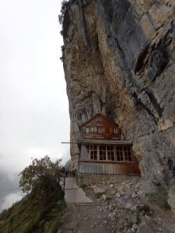 Blick auf die Aescheralp, die unter einem Überhang auf einer Felskante steht