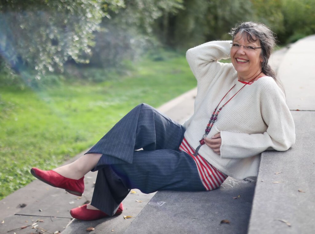 Ulrike Wanner sitzt im Park auf Stufen zum Ufer