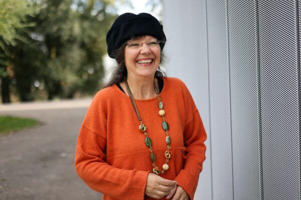 Ulrike Wanner mit schwarzer Mütze und orangem Pulli im Park