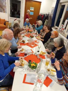 Ehrenamtliche des Blauen Hauses sitzen an der Tafel
