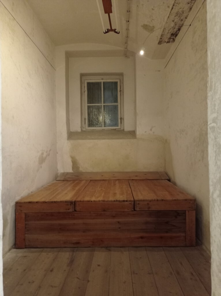 Holzpodest als Bett für 5 Personen in der schmalen Zelle