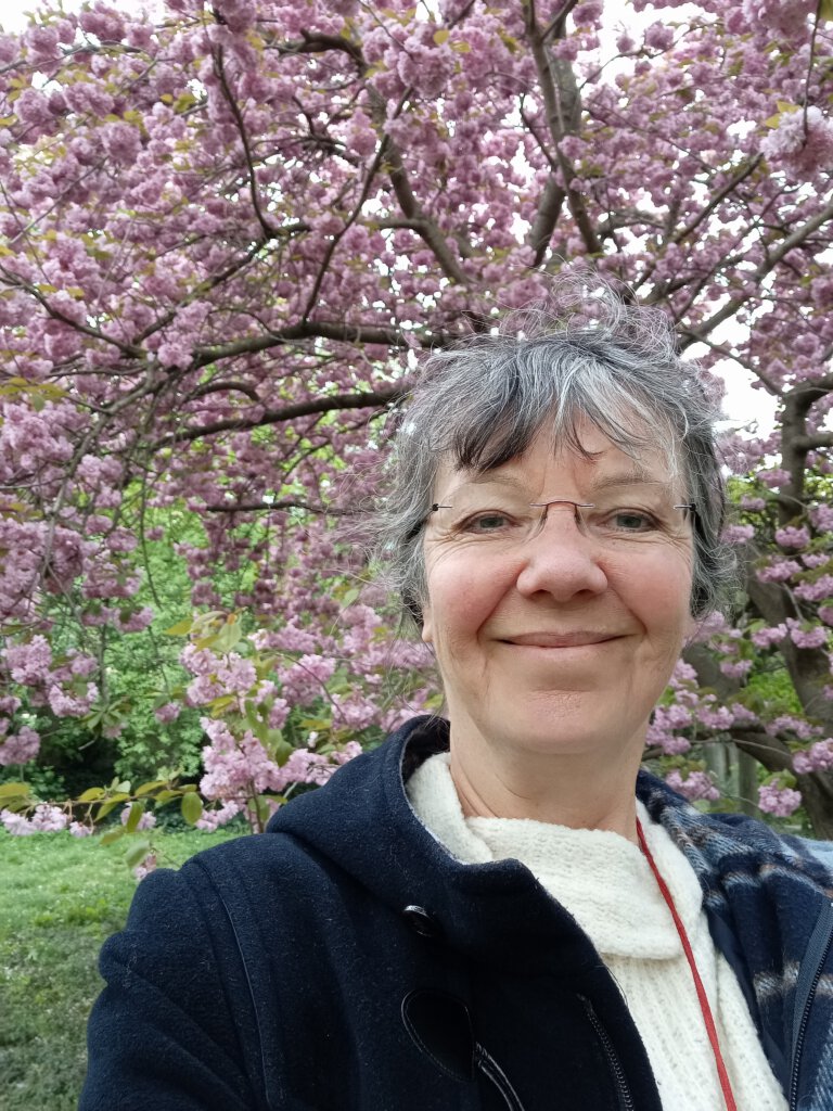 Ulrike vor blühendem Kirschbaum im Park an der Elbe