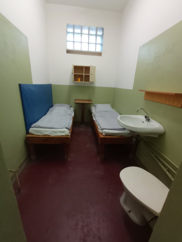 Schmale Zelle für zwei Personen mit Pritschen, Toilette, Waschbecken