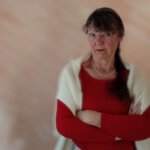 Ulrike Wanner mit verschränkten Armen und skeptischem Blick, Sinnbild für den Zweifel am Glaubenssatz 'Streit alleine lösen'.