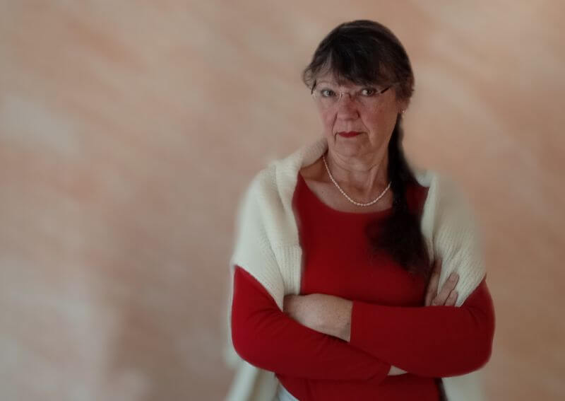 Ulrike Wanner mit verschränkten Armen und skeptischem Blick, Sinnbild für den Zweifel am Glaubenssatz 'Streit alleine lösen'.