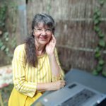 Ulrike Wanner sitzt mit Laptop im Garten