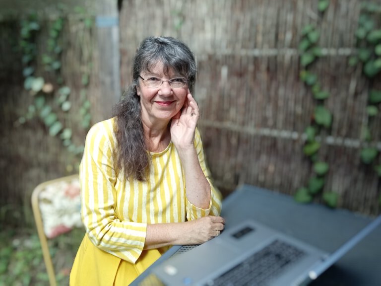 Ulrike Wanner sitzt mit Laptop im Garten