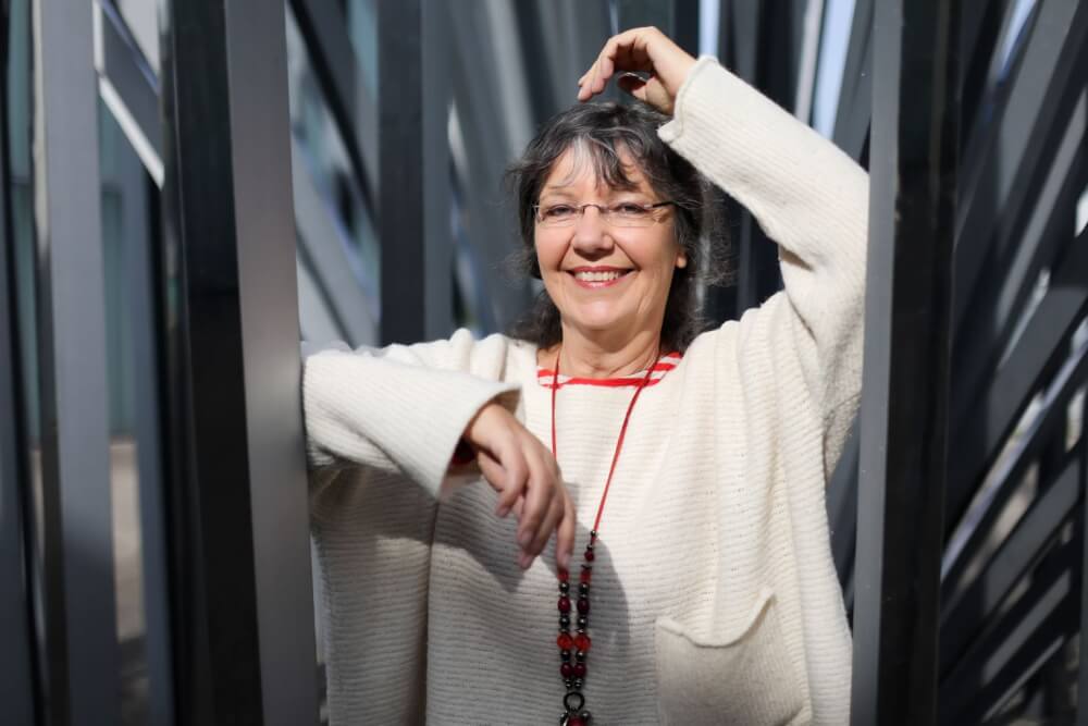 Ulrike Wanner, Mediatorin bei Alles Porträtfoto von Ulrike Wanner, Mediatorin und Inhaberin von Alles gut Mediation, aufgenommen im Freien zwischen schmalen Metallstreben. Verwendet als Beitragsbild für den Artikel 'Klarheit statt Win-Win': 5 Dinge, die ich als Mediatorin heute anders machen würde'