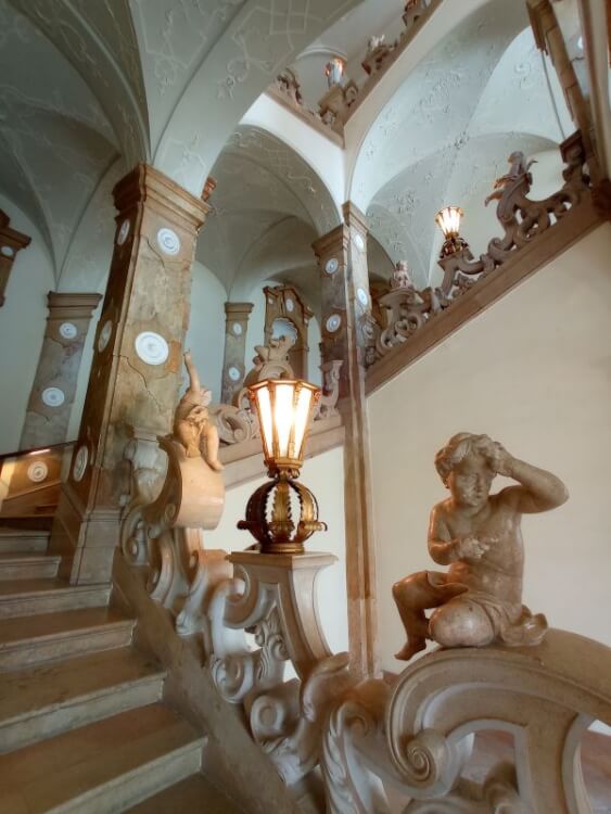 Marmortreppe im Schloss Mirabell mit Putten-Figuren auf dem Geländer, Laterne und stuckverziertem Gewölbe