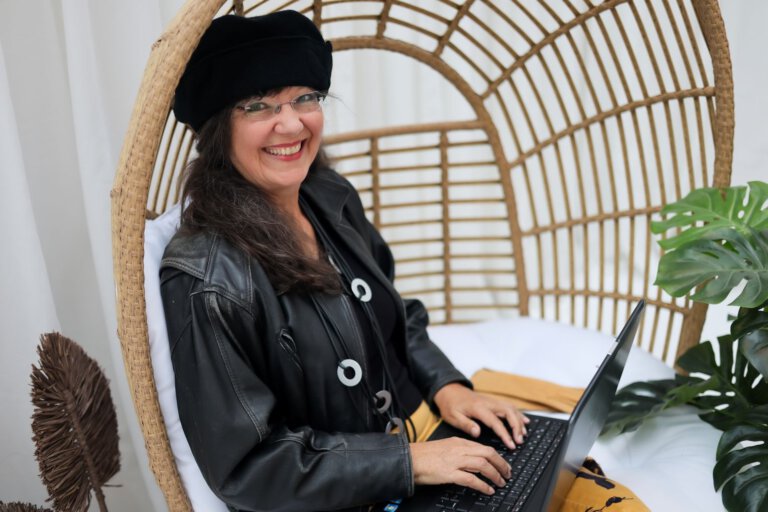 Ulrike Wanner mit Laptop im Rattan-Sessel, Autorin der Umfrage zum Thema Konflikt mit KI lösen.